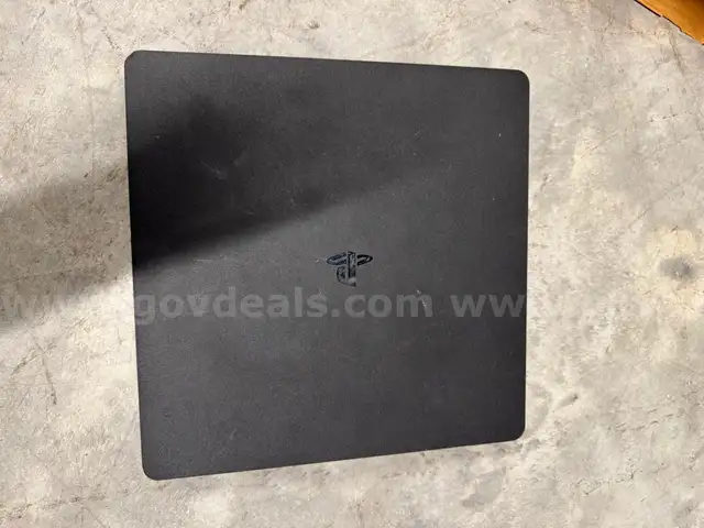 Black PS4 with controllers and PS4 game disc