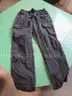Several Bags Of Black Utility Pants