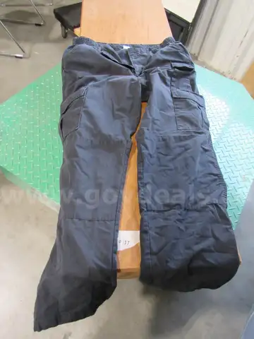 Several Bags Of Black Utility Pants