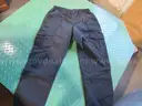 Several Bags Of Black Utility Pants