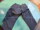 Several Bags Of Black Utility Pants