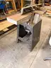 Used industrial woodworking jointer mounted on a metal stand