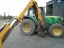 John Deere 6115M with extended mower attachment.