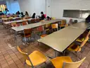 Various furniture items that were once used in a lounge space / cafeteria including chairs, tables