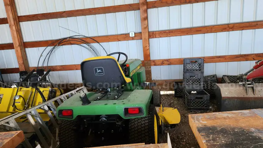 1990 John Deere 318 Tractor with Roto Tiller, Snow Blade, Mid Mount Mower, Snow Blower, and Cabin Enclosure Attachments