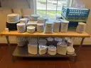 White plates and cups of different sizes suitable for a dining setup in a restaurant.