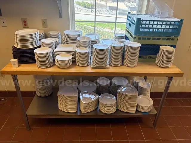 White plates and cups of different sizes suitable for a dining setup in a restaurant.