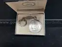 KEY CHAIN WITH MORGAN DOLLAR AND TAG WITH "RUBY 1962" INSCRIBED, IN BOX