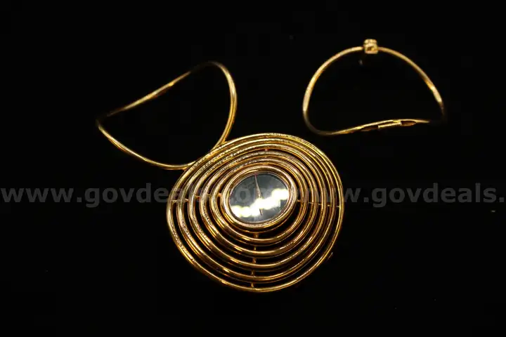 Gold colored Geneva like watch in an ornate gold colored broken band