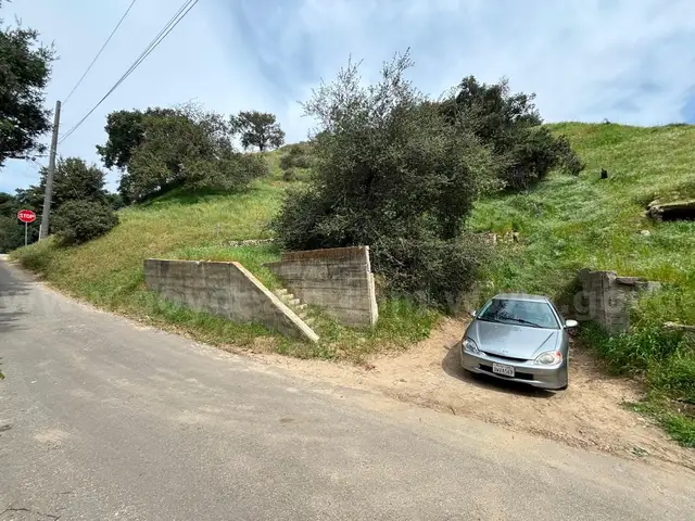 Vacant land in San Fernando with existing house foundations and address.