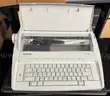 Brother ML 100 Standard typewriter with lid, various ribbons and corrective film ribbons, and cushioned pad (works!)
