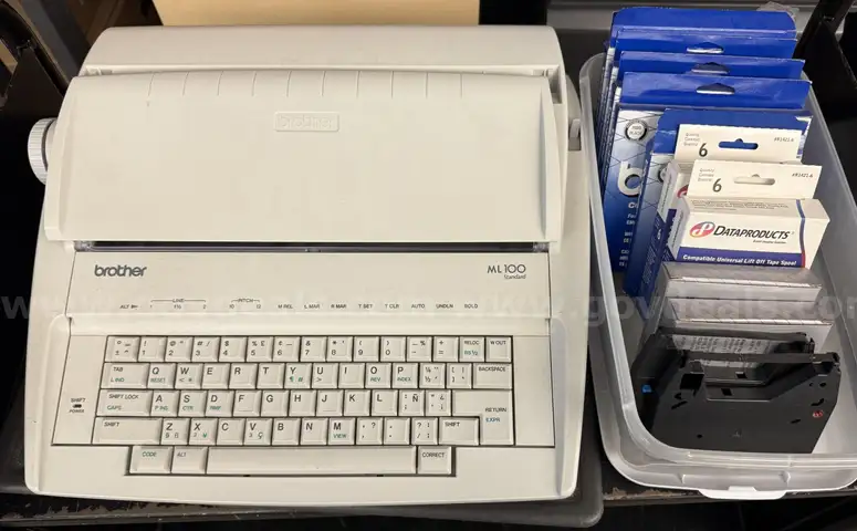Brother ML 100 Standard typewriter with lid, various ribbons and corrective film ribbons, and cushioned pad (works!)