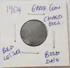 1904 INDIAN HEAD ERROR COIN, BOLD LETTERS, CHIPPED EDGE.