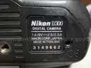 (1) USED BLACK, NIKON DIGITAL CAMERA D300, BODY ONLY; (1) USED BLACK, VIVITAR SERIES 1 FLASH ATTACHMENT, DF-383-NIK
