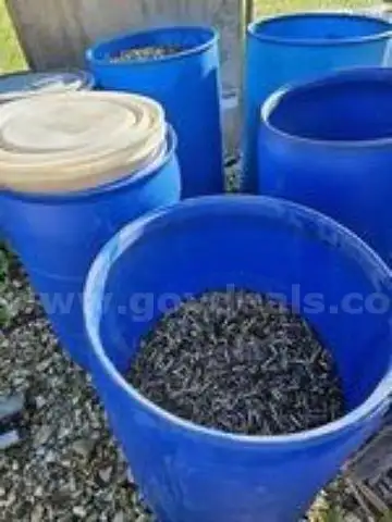 BRASS AMMUNITION SHELLS IN A BARREL ON A PALLET