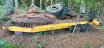 assortment of old bush hogs and trailers