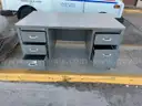 Lot of old toolboxes, under-vehicle creepers, retractable fluorescent lights, and a metal desk