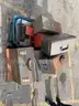 Lot of old toolboxes, under-vehicle creepers, retractable fluorescent lights, and a metal desk