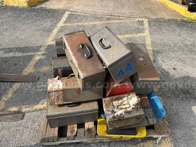 Lot of old toolboxes, under-vehicle creepers, retractable fluorescent lights, and a metal desk