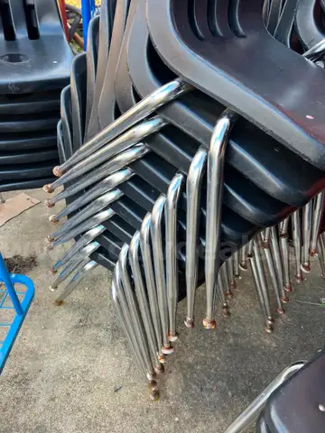 Lot of black, plastic, stackable chairs.