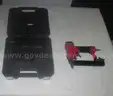 pneumatic nailer/stapler with case and a storage bin.
